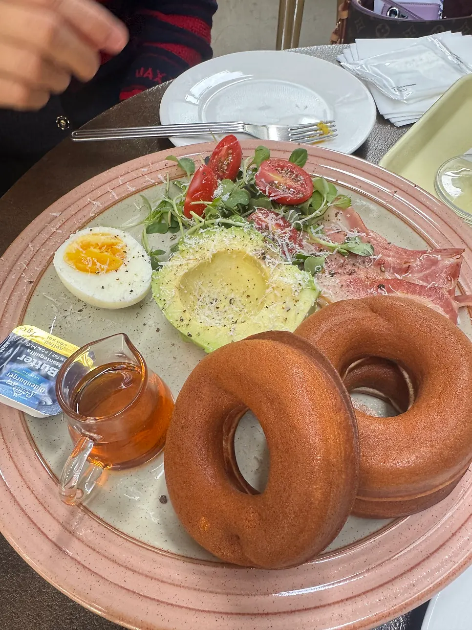 Pancake plate topped with avocado, jamón, and soft-boiled egg