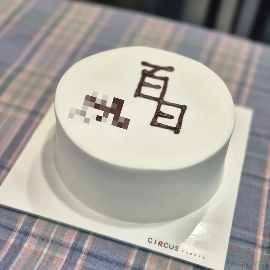 All-white lettering cake with clean, minimal icing