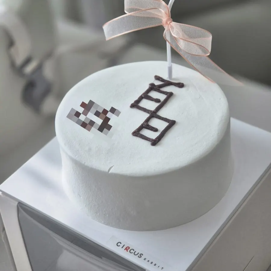 Close-up of the simply designed 100-day lettering cake