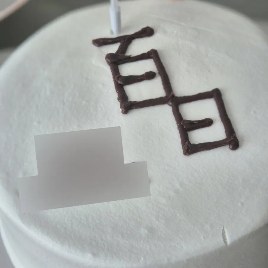 Whipped cream cake topped with chocolate lettering