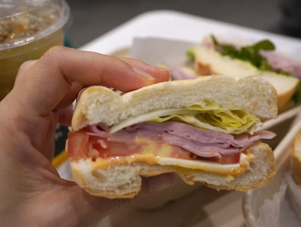 Picking up a piece of the crispy baguette sandwich