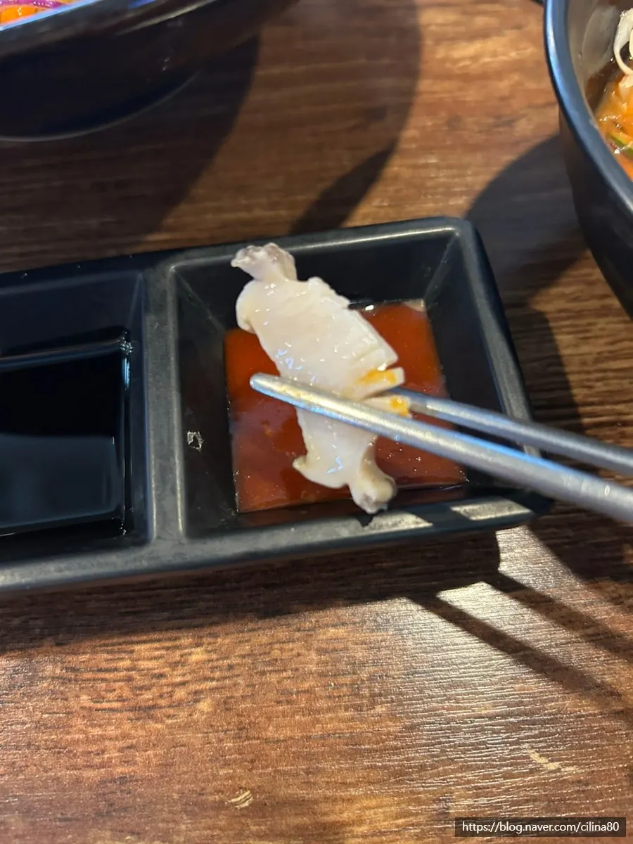 A piece of sashimi wrapped in a perilla leaf