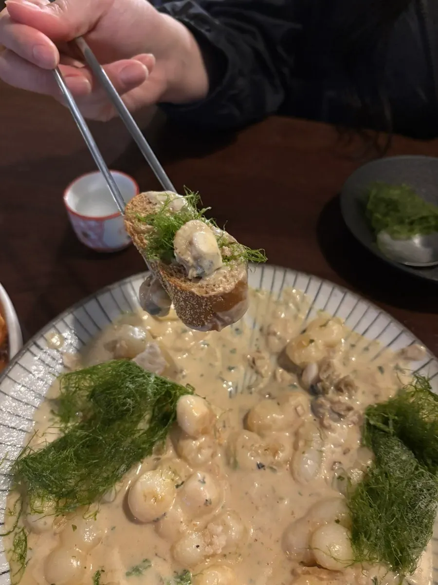 Bread topped with cream sauce, sea tangle, and scallop
