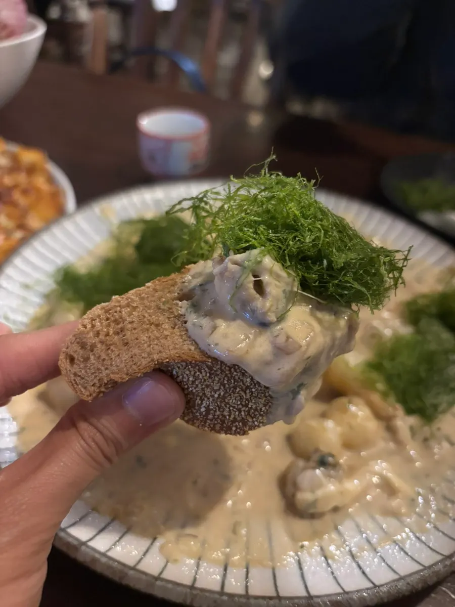 A piece of bread topped with sea tangle and scallop