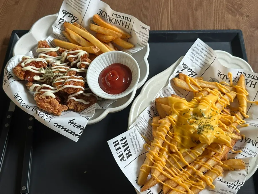 Cheese fries and seasoned chicken laid out on the table