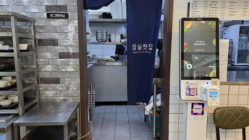 화이트톤 벽과 우드 테이블의 잠실첫집 내부