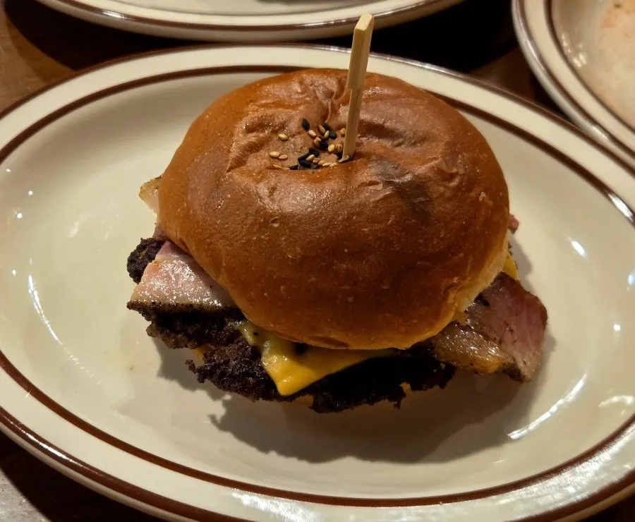 Close-up of a handmade burger with a thick patty stuffed between the buns
