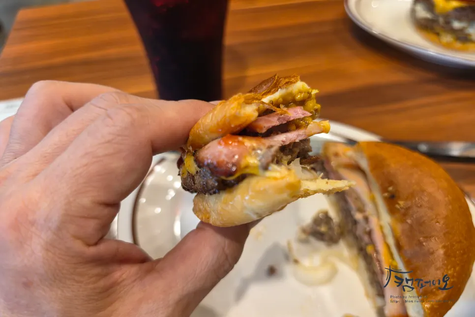 Cross-section of the burger with cheese spilling from the bun
