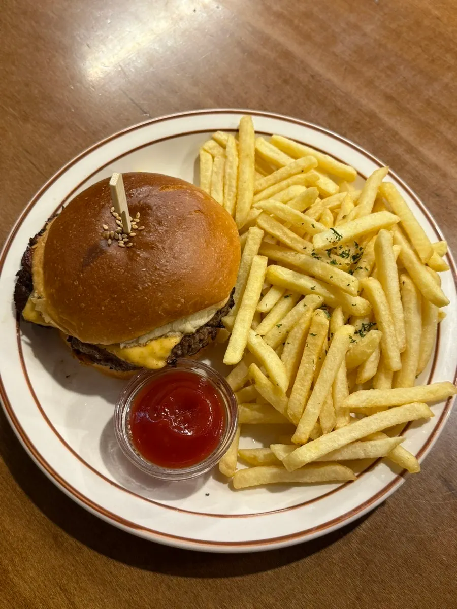 Double cheeseburger dipegang dengan satu tangan