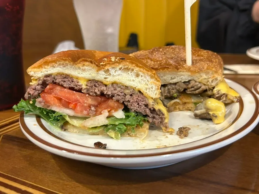 Cross-section of the burger stacked with bread, meat, cheese and vegetables
