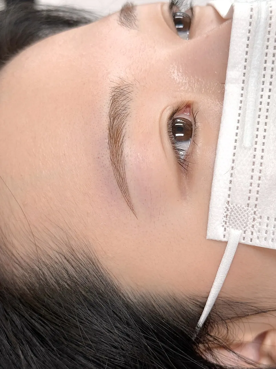 Result of the bright-colored eyebrow tattoo matched to bleached hair