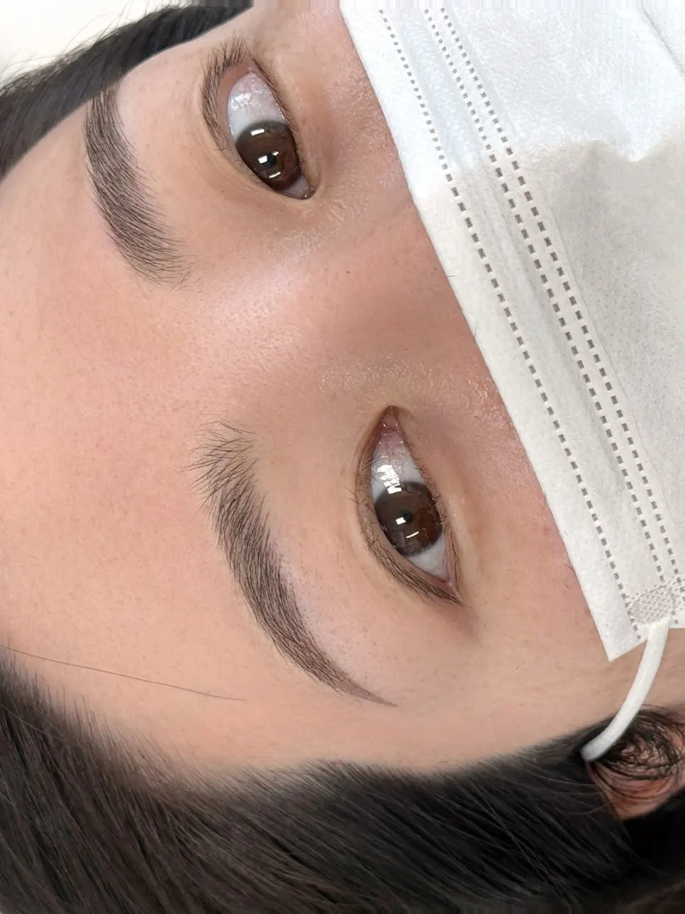 Close-up of the finished brows combining strokes and shading