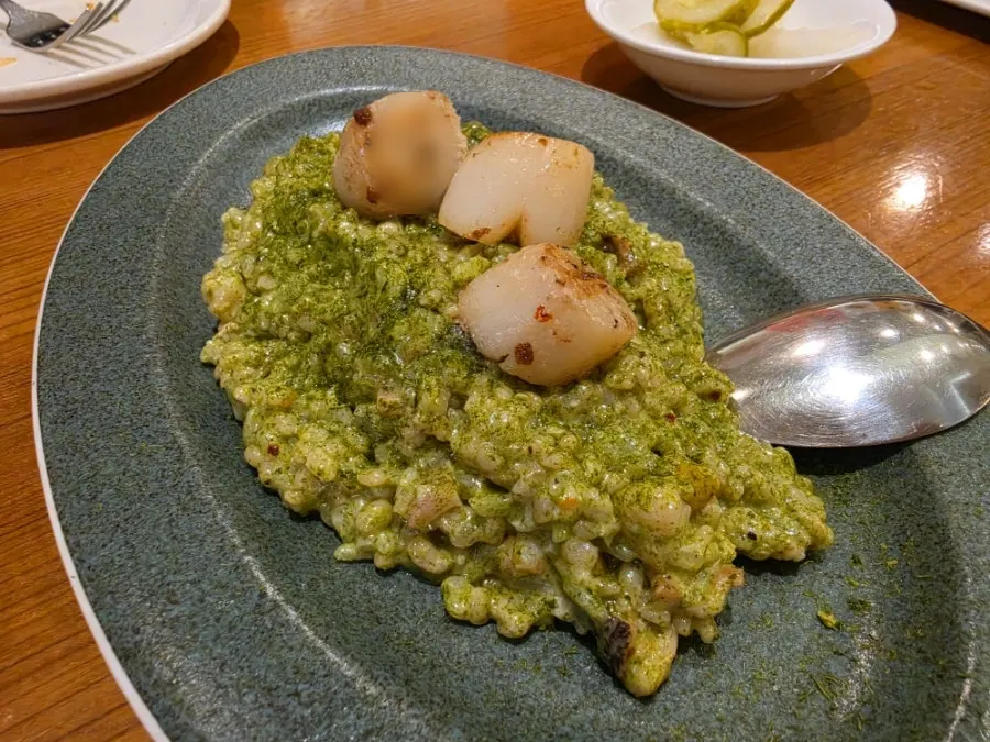 Table setting with gim pesto seafood barley risotto