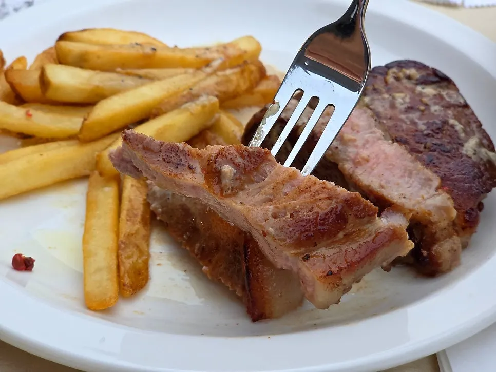 Pork neck steak disajikan dengan kentang goreng