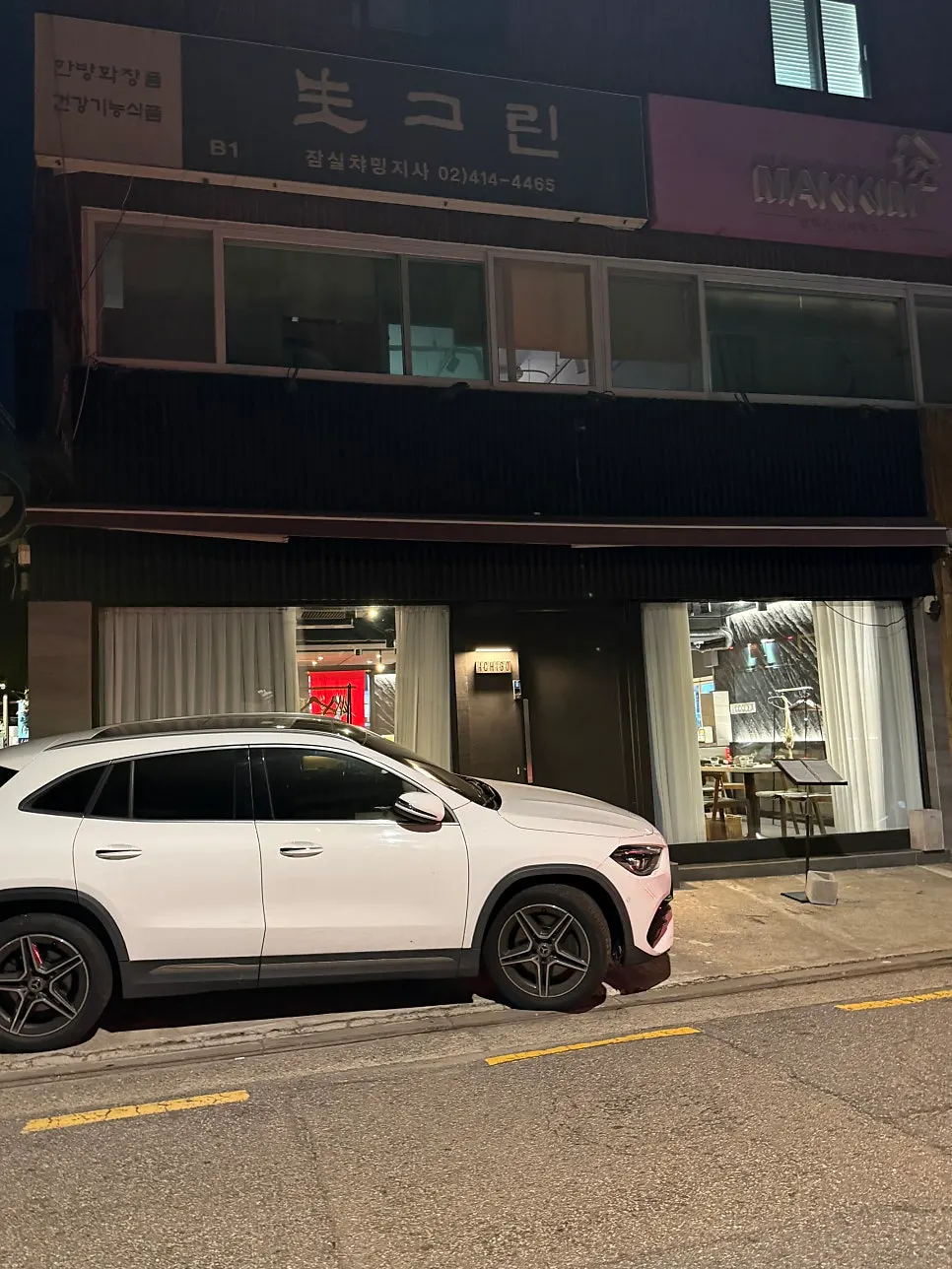 Cars parked in the alley in front of the shop