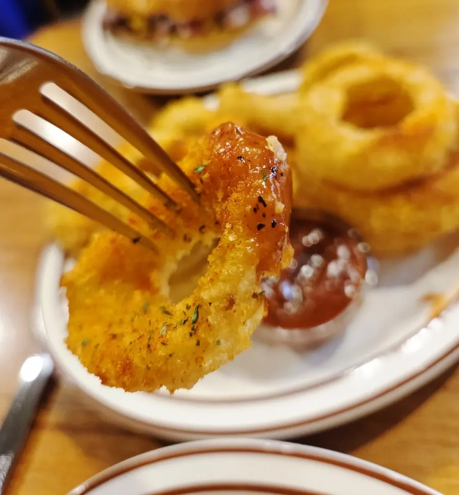 Cross-section of an onion ring dipped in hot ketchup sauce