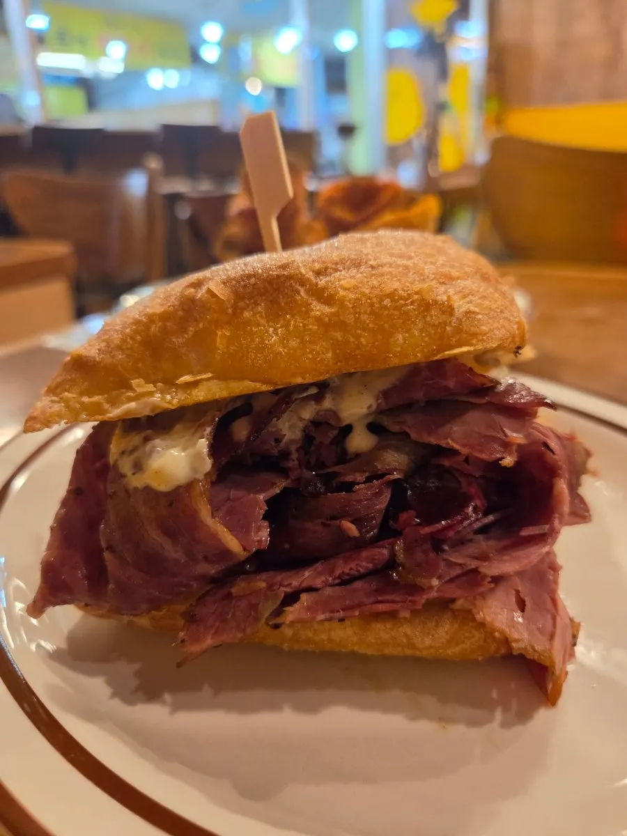 Pastrami sandwich with meat spilling out of the ciabatta