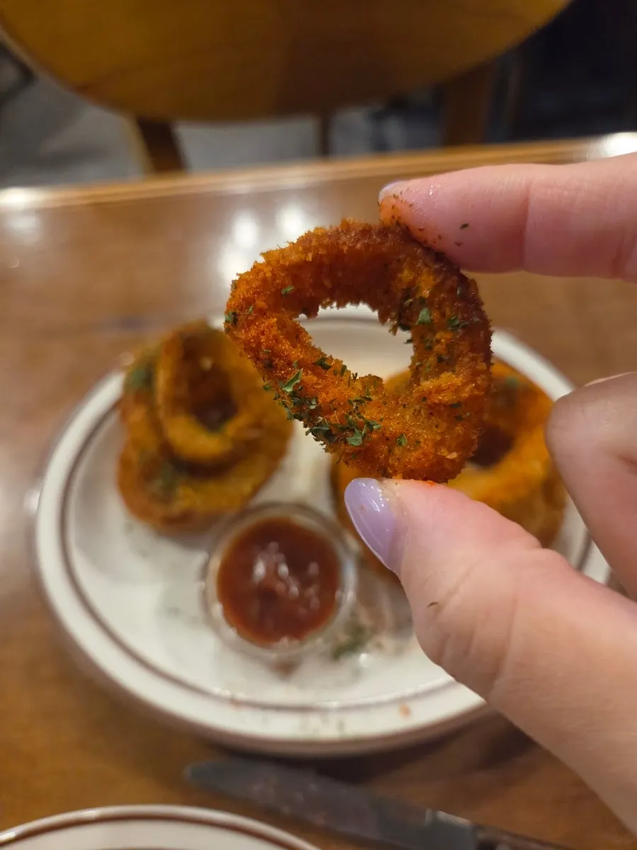 Dipping an onion ring into sauce