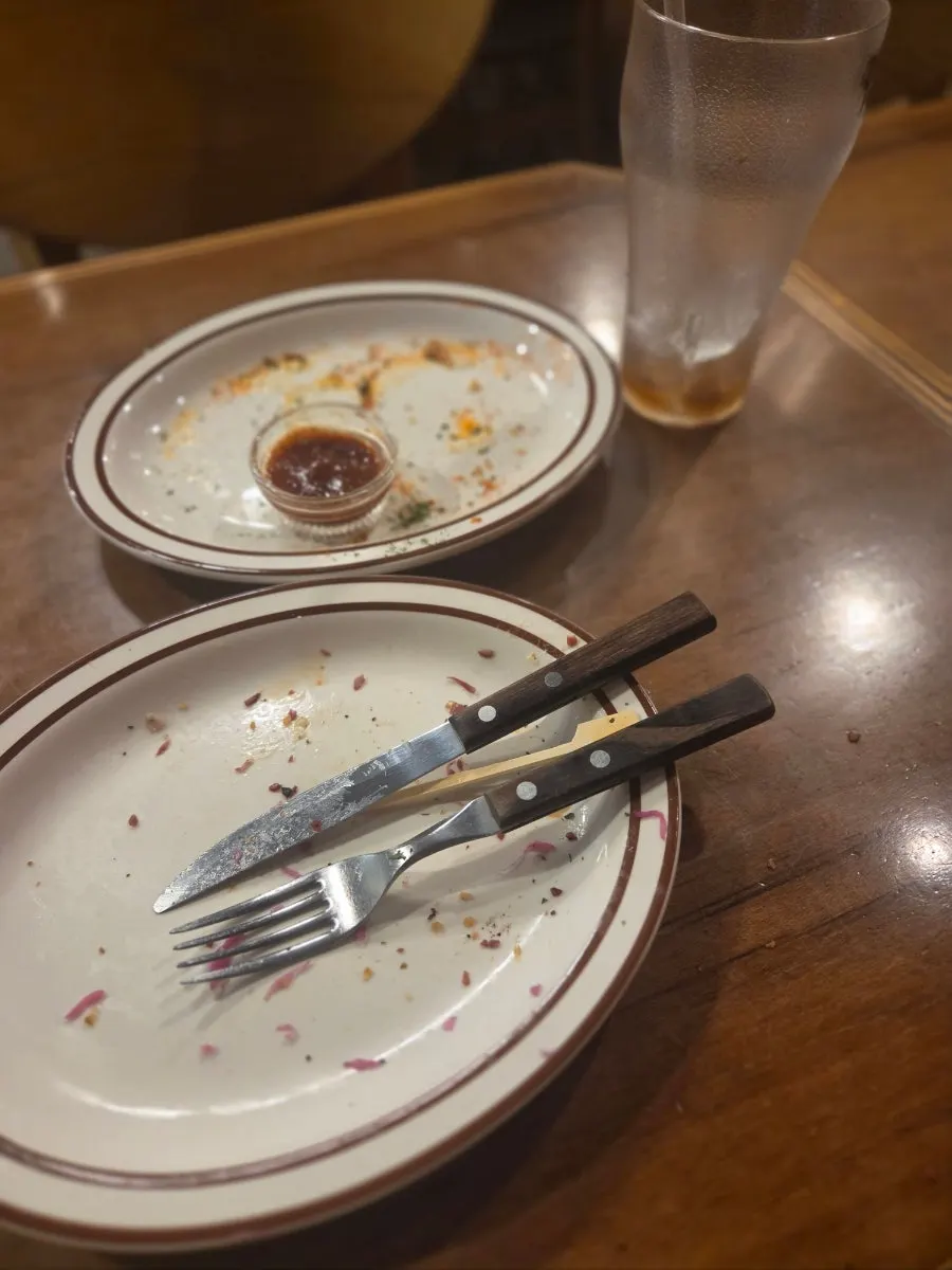 Table set with the sandwich, onion rings, and cola