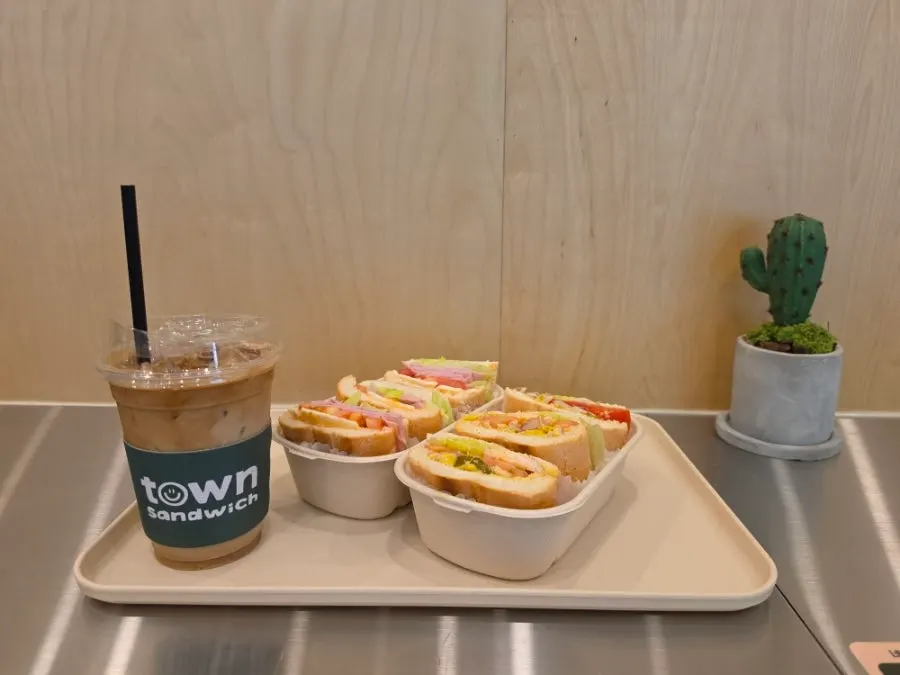 Table spread of Town Sandwich, grilled chicken banh mi, and caffè latte
