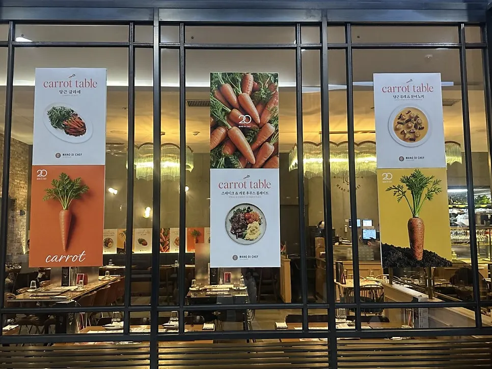 Banner mùa Carrot Table treo ở lối vào quán