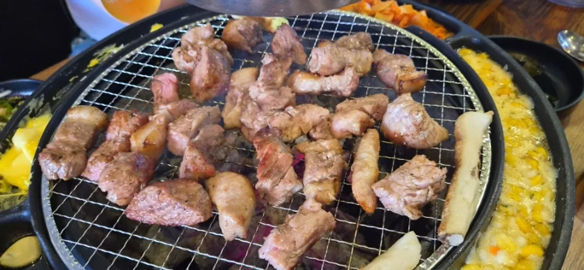 불판 위 목살과 사이드 메뉴