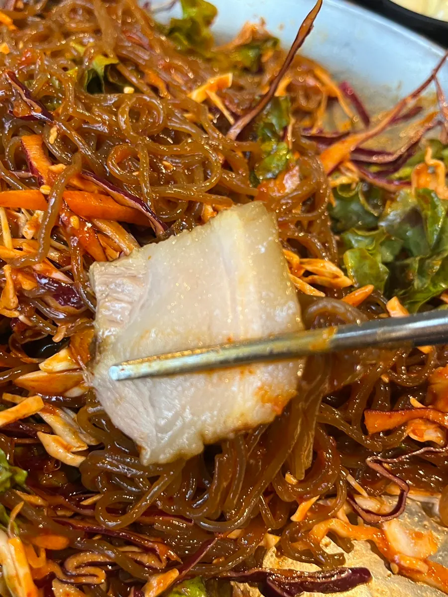 A bite combining bossam and jaengban makguksu together