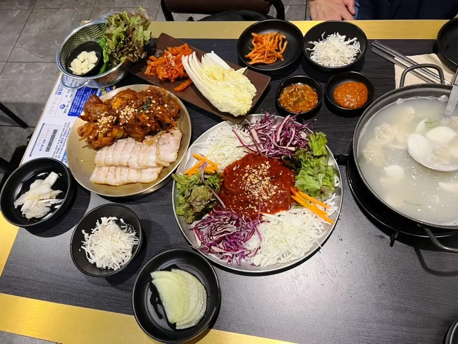 Table set with fire jokbal, bossam, and jaengban guksu