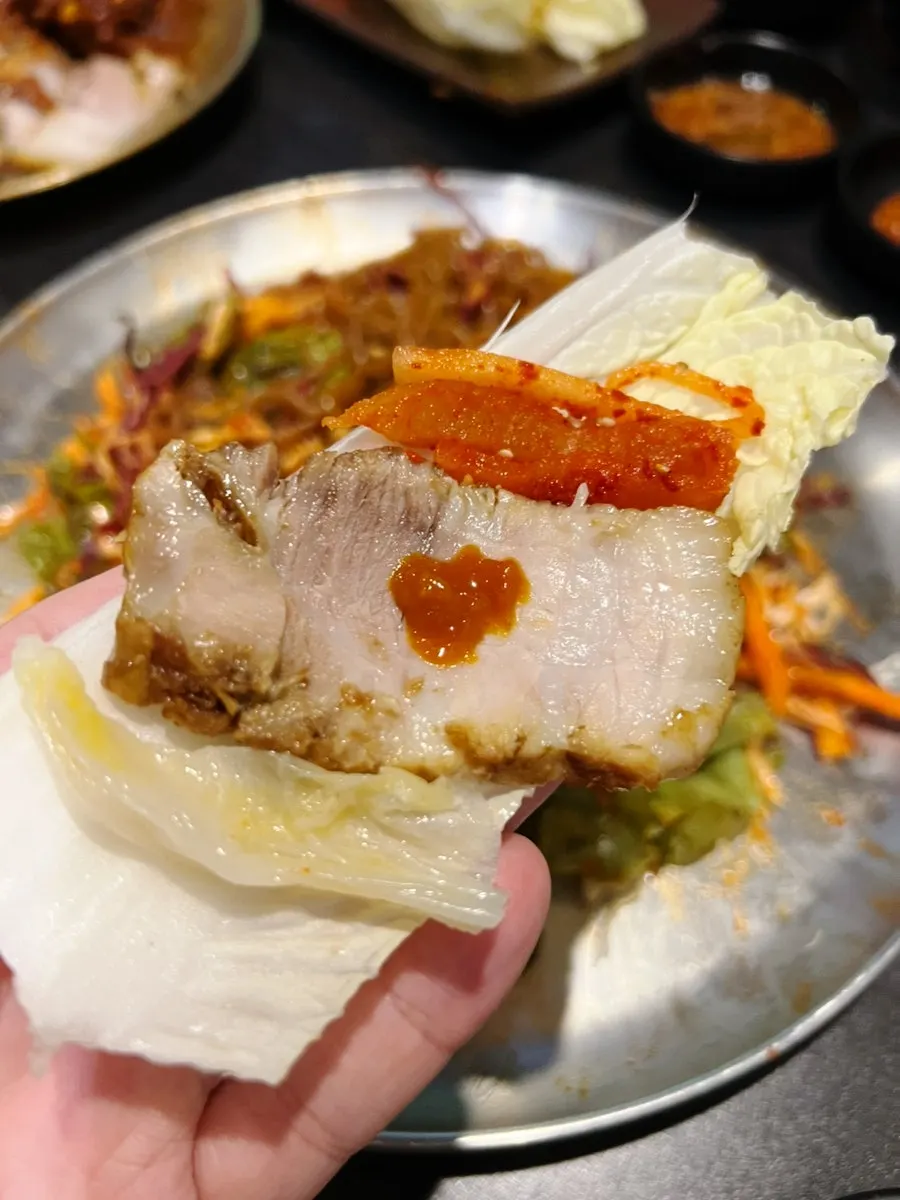 A piece of bossam with salted shrimp sauce