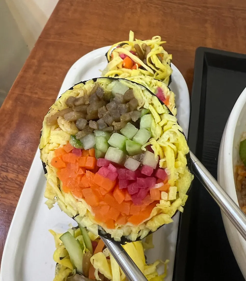 A solo dining spread of octopus bibimbap and gimbap together