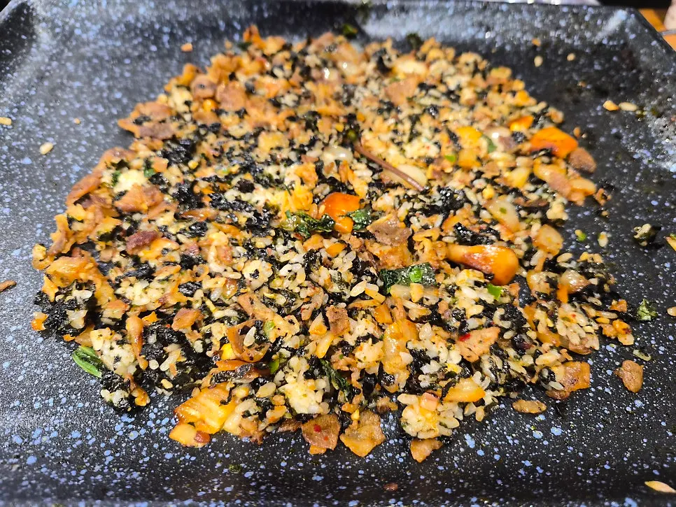 Finished fried rice topped with seaweed flakes and spicy sauce