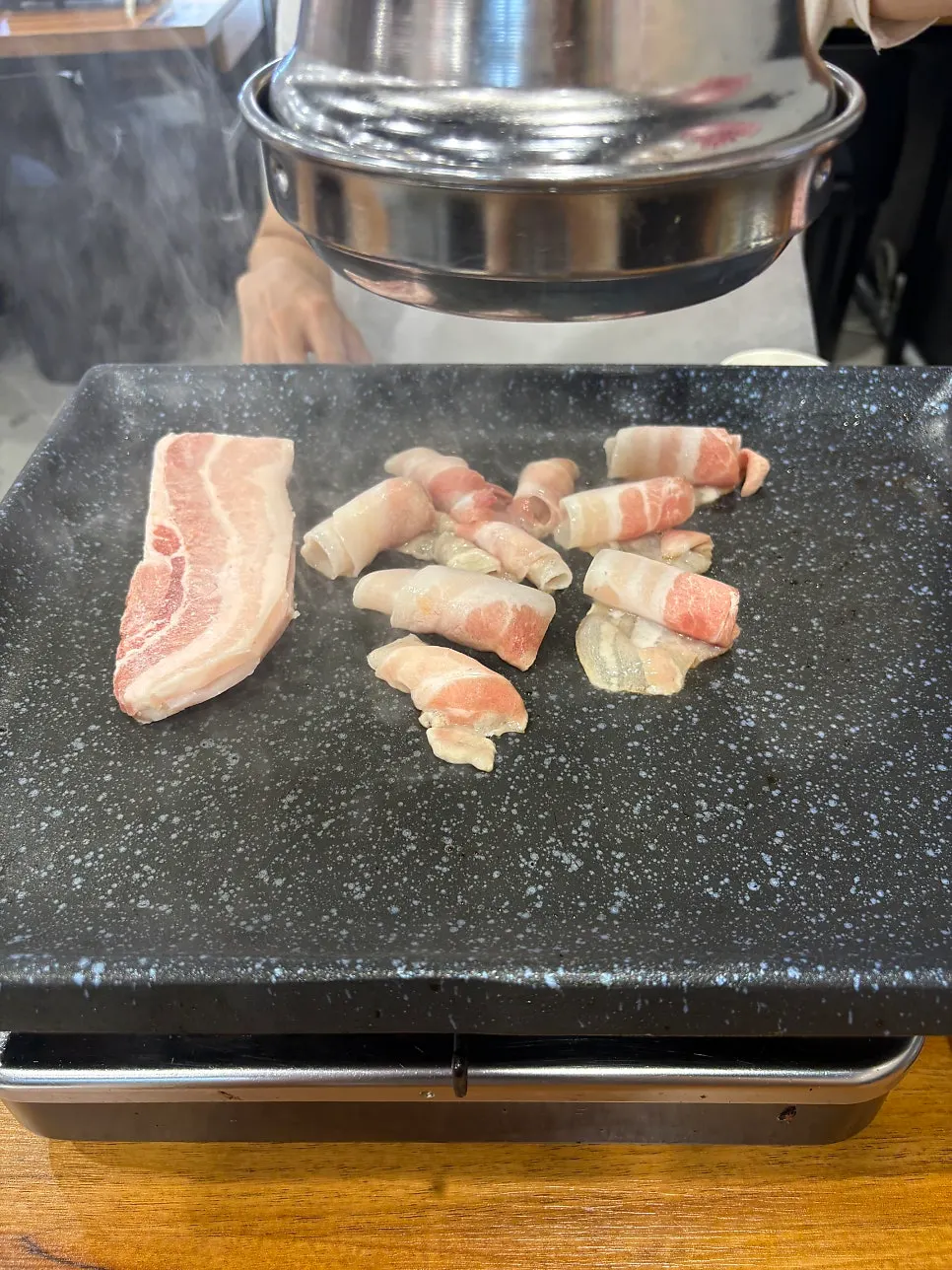불판에 올린 냉동삼겹살과 대패목살