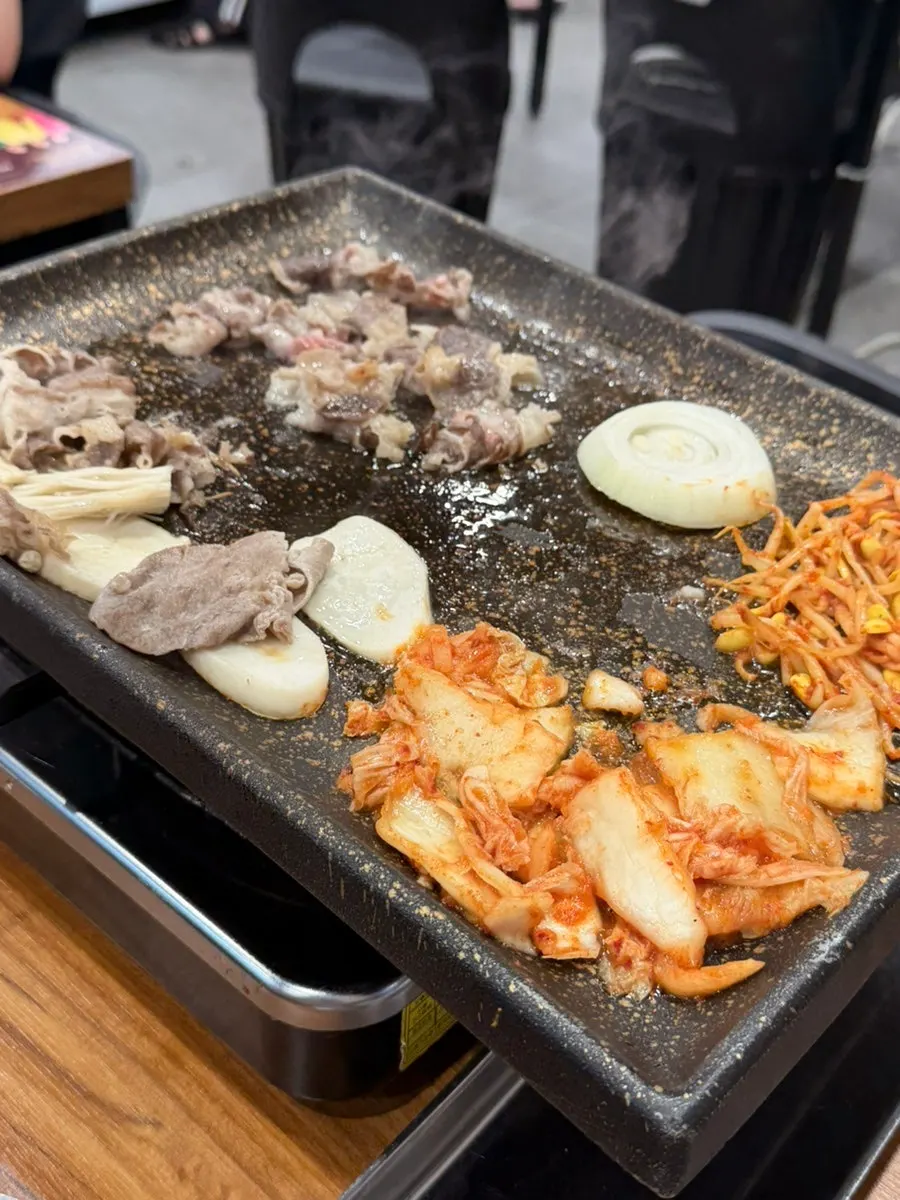 A spread of rice, side dishes, and grilled meat