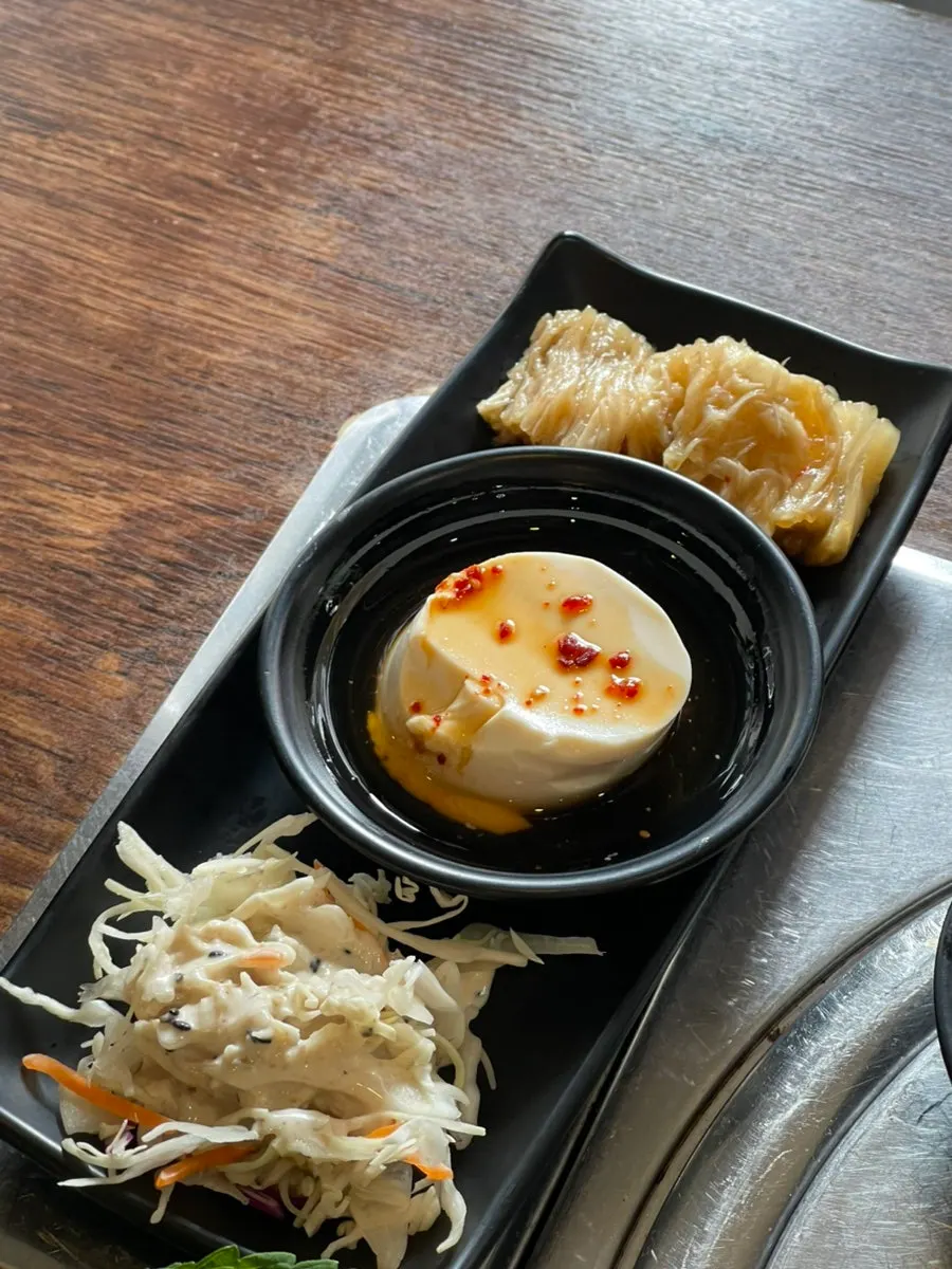 Salad, tofu, and aged kimchi served as banchan