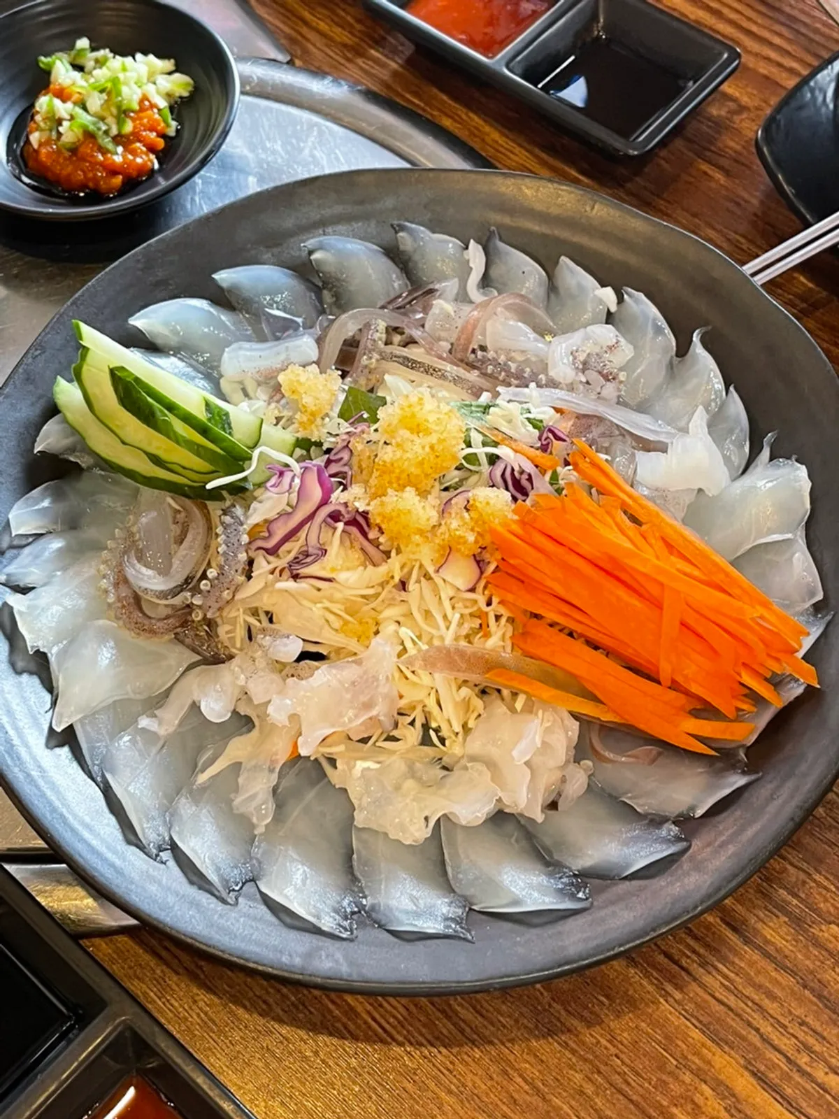 Plate of ojingeopo topped with shredded cabbage and flying fish roe