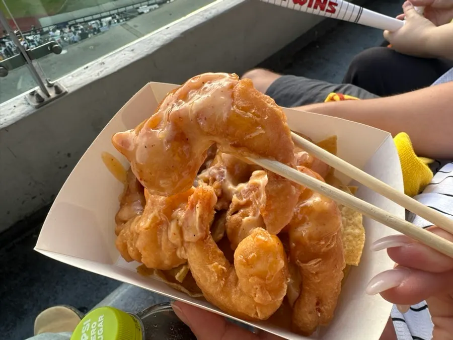A plump cream shrimp lifted with chopsticks
