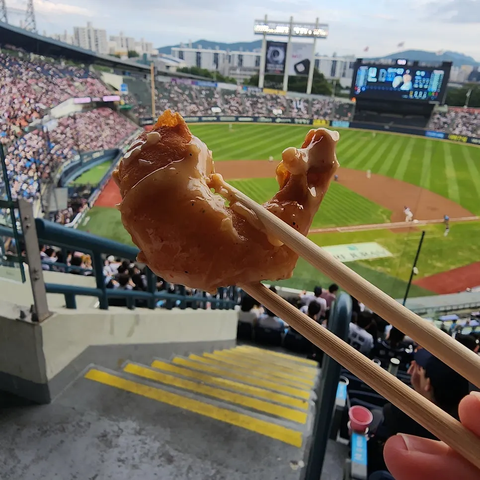 A single cream shrimp piece picked up with chopsticks