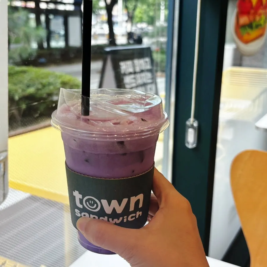 Ube latte and sandwich on the table