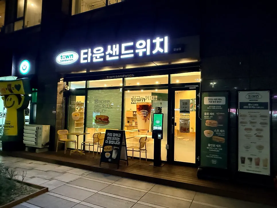 초록색 간판의 타운샌드위치 잠실점 외관과 야외 테이블