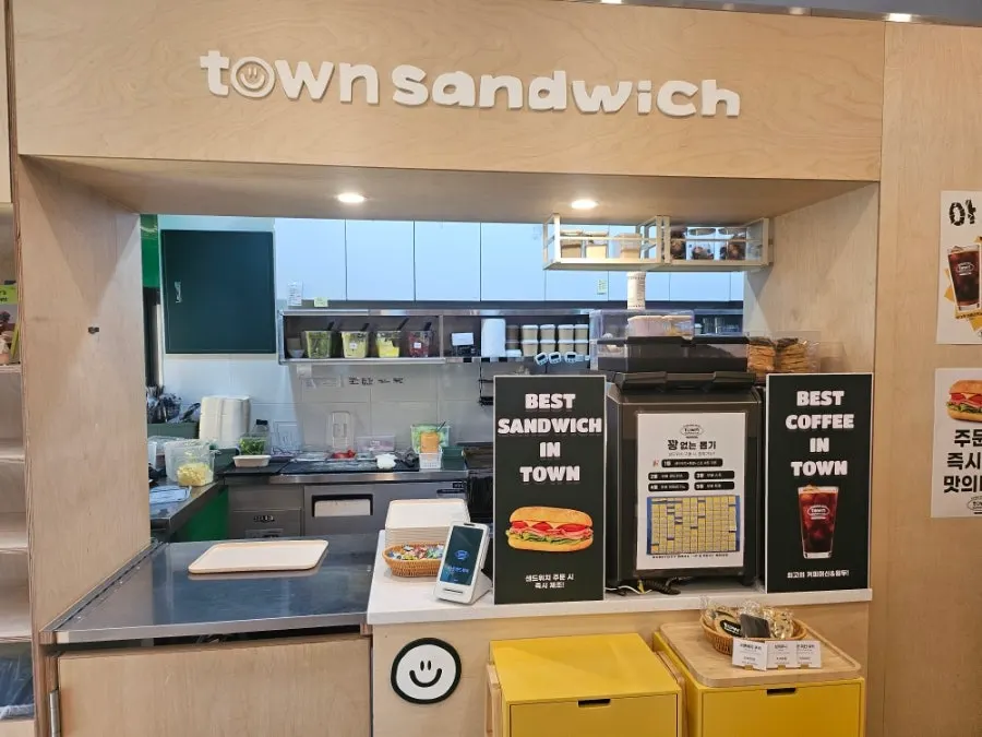 Wood-toned, neatly arranged interior of Town Sandwich Jamsil Branch