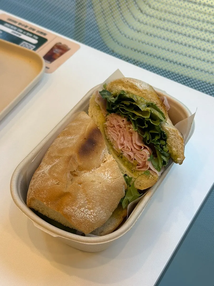 A bite taken out of the basil jambon-beurre