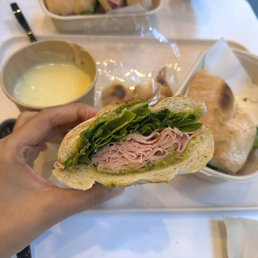 A full spread with sandwiches, soup, and a drink