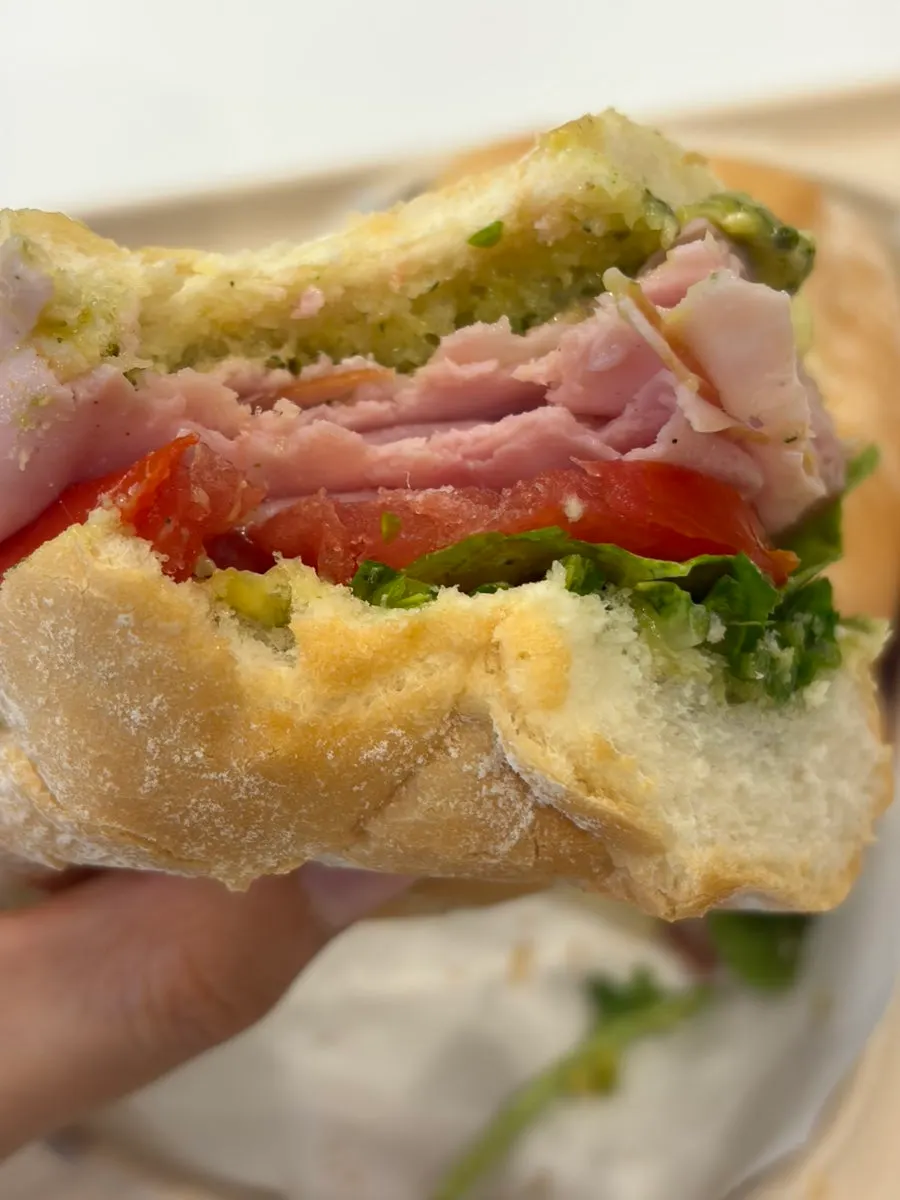 Fluffy baguette sandwich held in hand