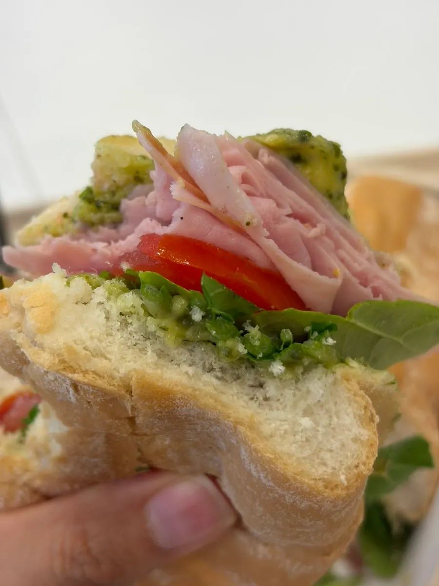 Basil jambon-beurre sandwich with a bite taken out