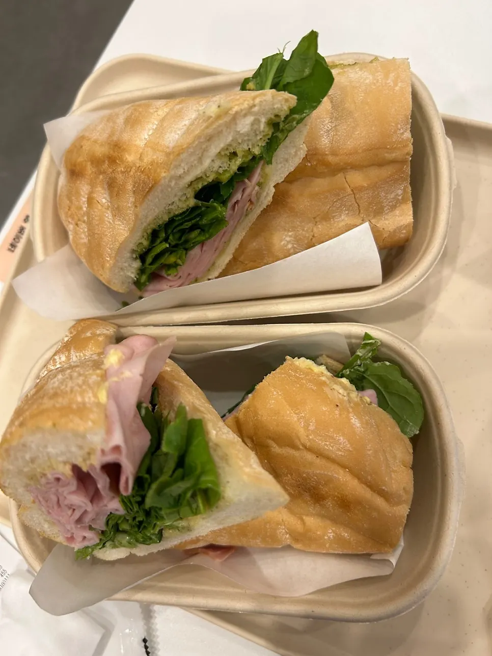 Two jambon-beurre sandwiches plated nicely for dine-in