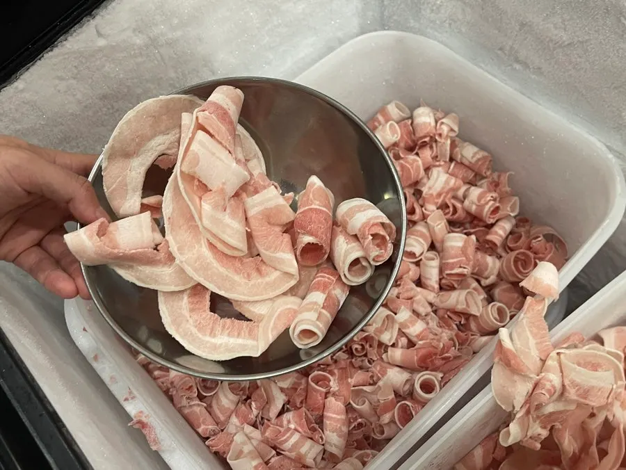Thin shaved pork grilling on the pan