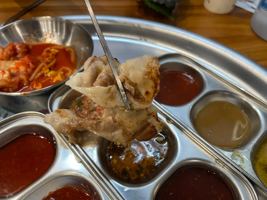 Shaved pork dipped in Goesan cheonggukjang sauce