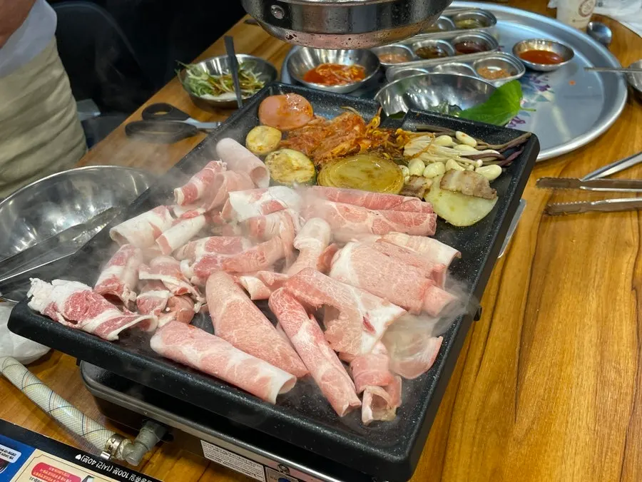 Pan with kimchi and mushrooms grilled alongside meat