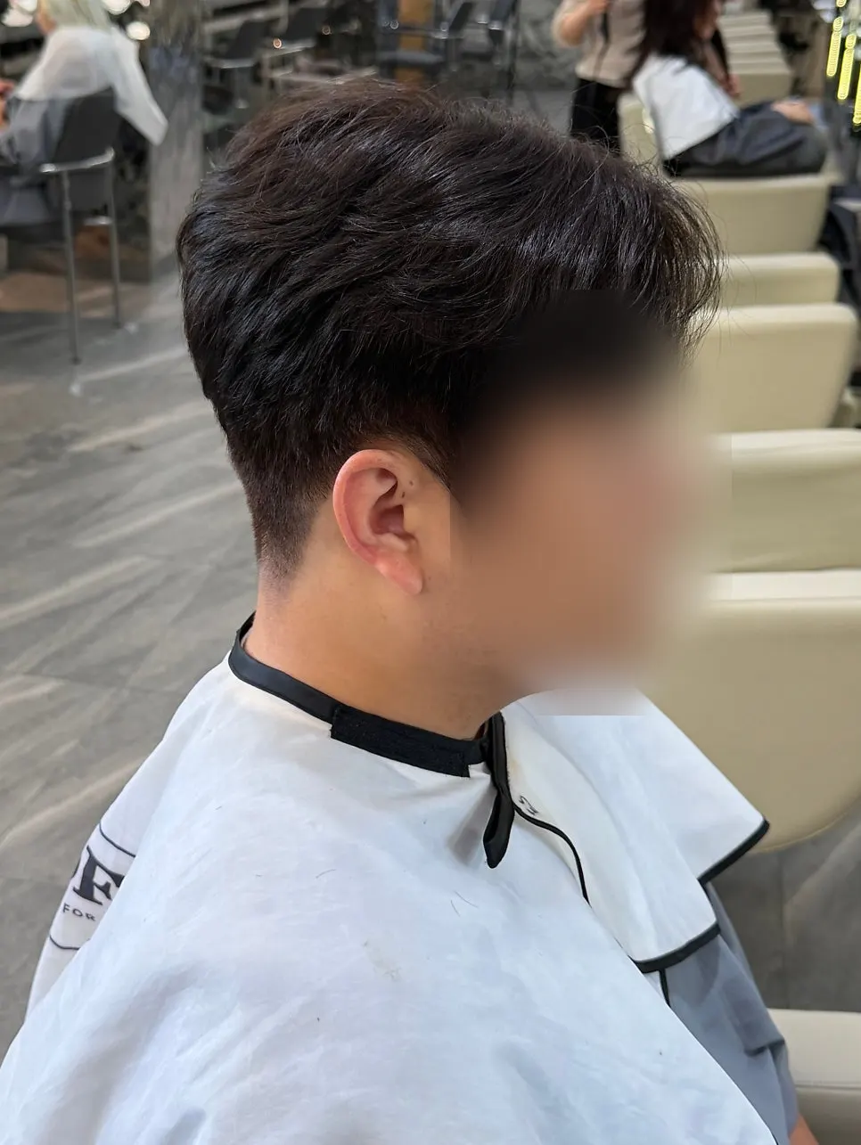 Ash brown hair styled neatly after the cut