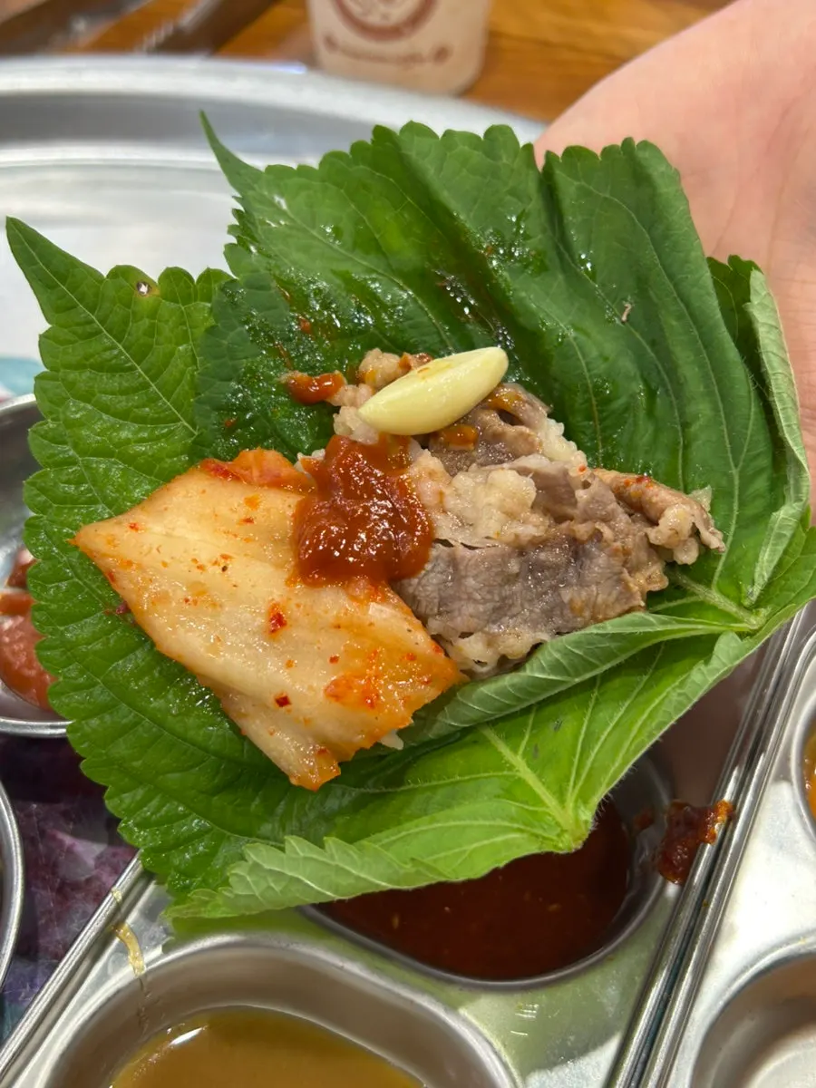 Shaved pork belly and vegetables grilling on the pan